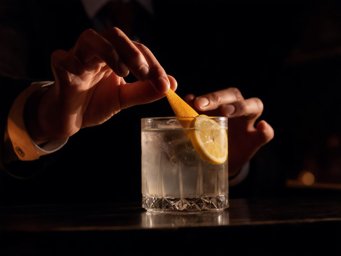 Barkeeper garniert einen Drink mit Zitrustwist